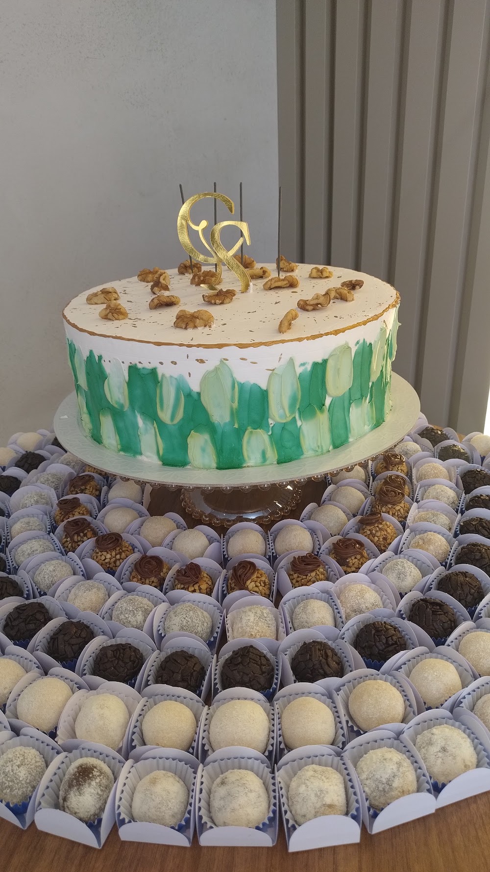 Mesa de docinhos e brigadeiros gourmet ao lado de bolo de aniversário, produzidos pelo Castelo Dos Bolos